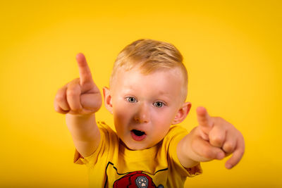 Portrait of cute boy against yellow background