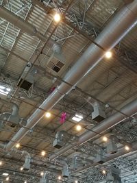 Low angle view of illuminated light bulb hanging from ceiling