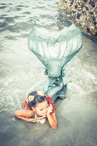 High angle view of girl wearing mermaid costume in water