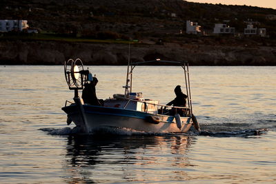 People in boat sailing on sea