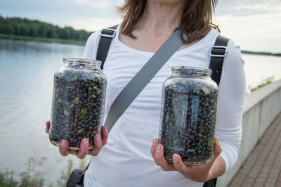 Midsection of woman holding glass jar