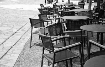 Empty chairs and tables at sidewalk cafe