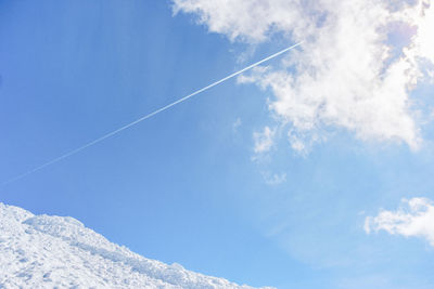 Low angle view of vapor trail in blue sky