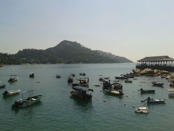 Boats moored in sea against clear sky