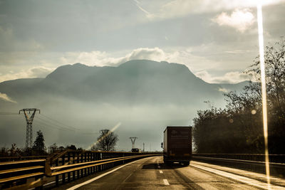 Road by mountain against sky