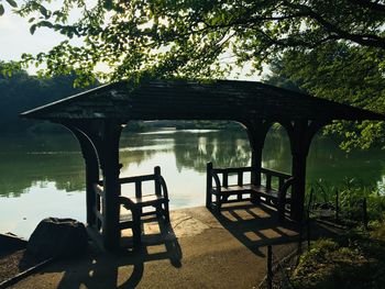 Empty bench by river in park