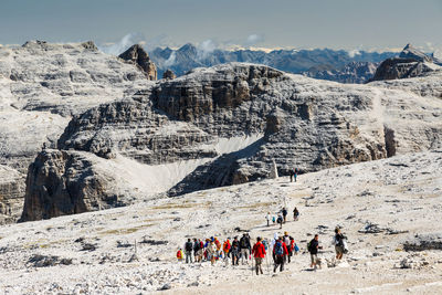 Group of people on rock against mountain range