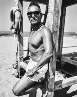 Portrait of man wearing sunglasses standing at beach