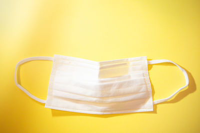 High angle view of paper on table against yellow background