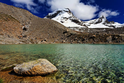 Scenic view of river by mountains against sky at gran paradiso national park