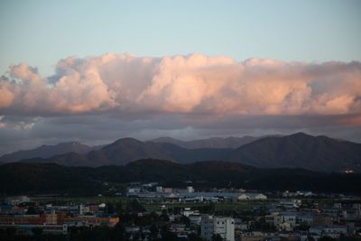 Houses in town against sky during sunset