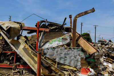 Low angle view of abandoned metal structure against sky