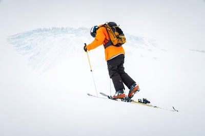 Winter skitour freeride in cloudy weather, snow-capped mountains against the backdrop of a glacier