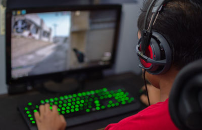 Cropped image of boy playing video game