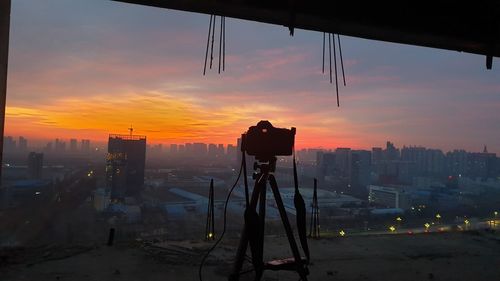 Silhouette buildings against sky during sunset