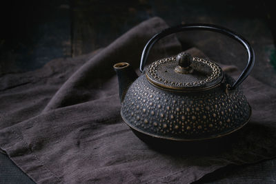 Close-up of old traditional teapot on textile