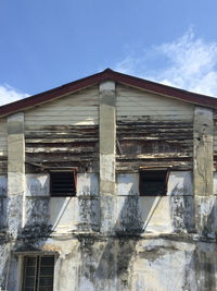 Low angle view of abandoned house against sky