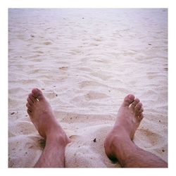 Low section of man standing on shore