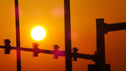 Silhouette gate against sky during sunset