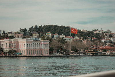 Buildings by sea against sky in town