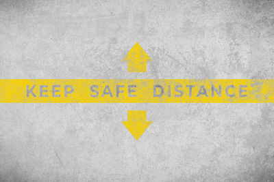 Close-up of yellow arrow sign on wall