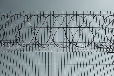 Barbed wire fence against clear sky