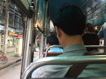 Rear view of man traveling in bus