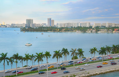High angle view of city by sea against sky
