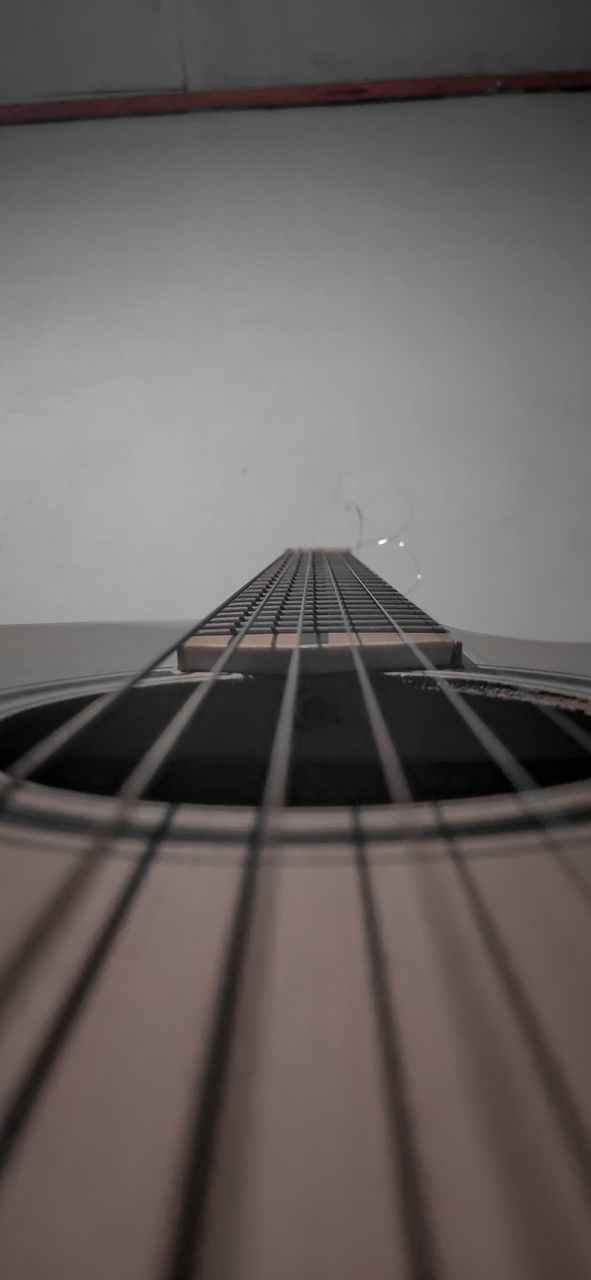 CLOSE-UP OF GUITAR AGAINST CEILING