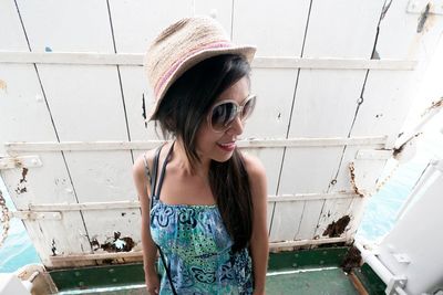 Portrait of beautiful young woman standing against wall