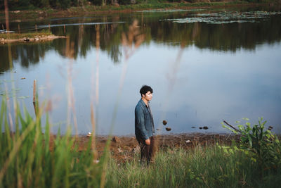 Young man standing at lake