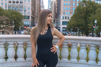 Full length of woman standing by tree in city