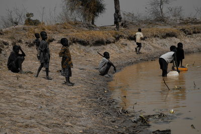 People playing on field against sky