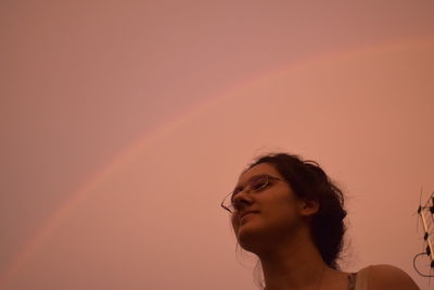 Low angle view of thoughtful woman standing against sky during sunset