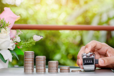 Close-up of hand holding coins on table