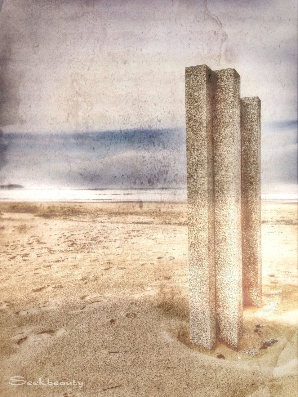 beach, sand, built structure, architecture, sea, building exterior, shore, sky, sunlight, day, horizon over water, outdoors, no people, wall - building feature, architectural column, wood - material, shadow, pattern, in a row, textured