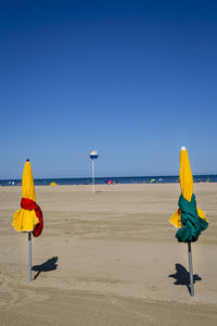 Umbrella on beach against clear blue sky