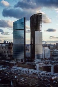 Modern buildings in city against cloudy sky