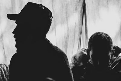 Rear view of silhouette people looking at window