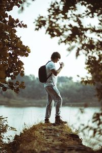 Full length of man standing by lake against sky