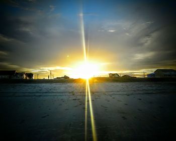 Road by sea against sky during sunset