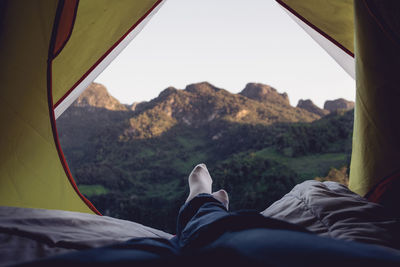 Low section of man resting on tent