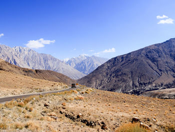 Scenic view of mountains against blue sky