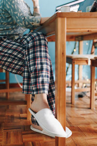 Low section of woman sitting on chair at home