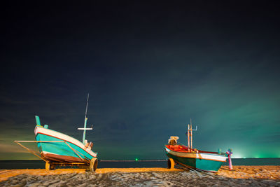 Boat moored on beach against sky