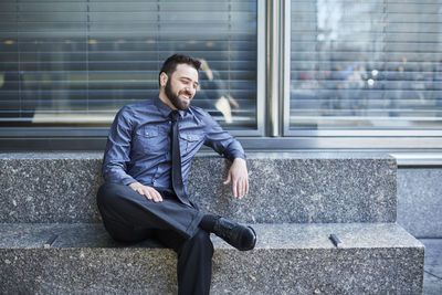 Portrait of a smiling young man sitting outdoors