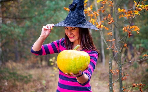 Halloween warm beautiful witch with pumpkin