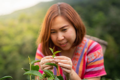 Portrait of beautiful woman holding fresh plant