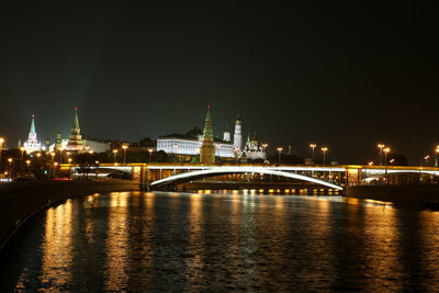 Illuminated bridge over river at night