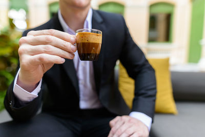 Midsection of man holding beer glass